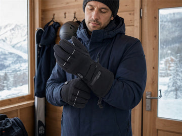 Beheizbare Skihandschuhe vor einem Wintertag im Schnee vorbereiten
